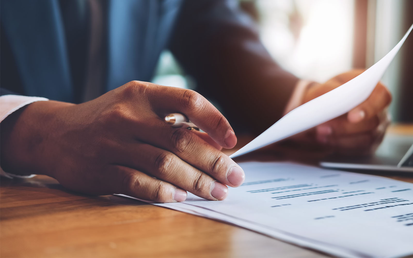 Man reading letter with pen in hand