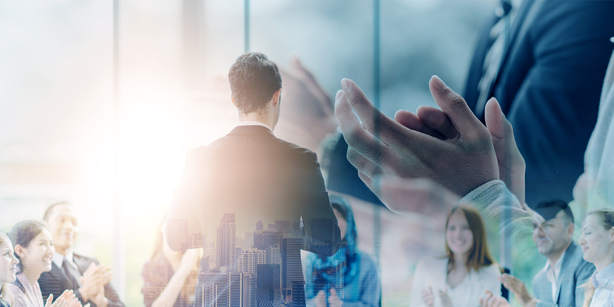 Digital composite image of business people clapping and office buildings