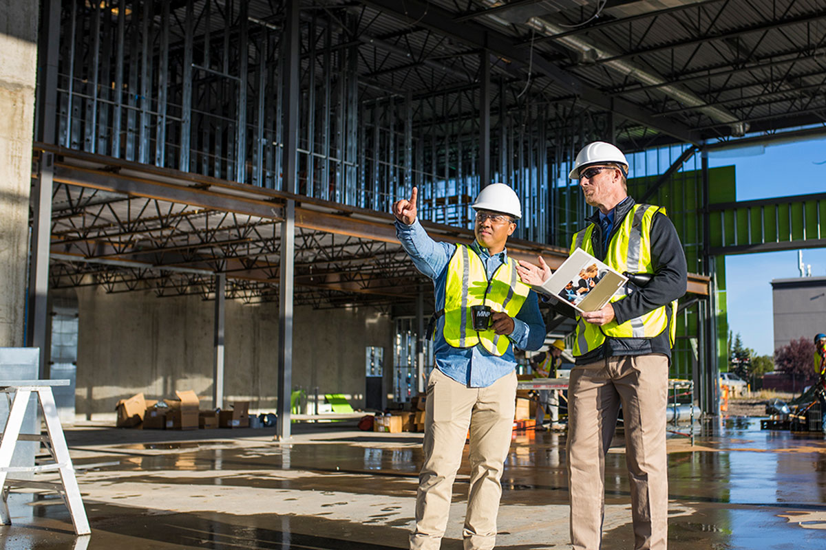Two construction workers on site reviewing project