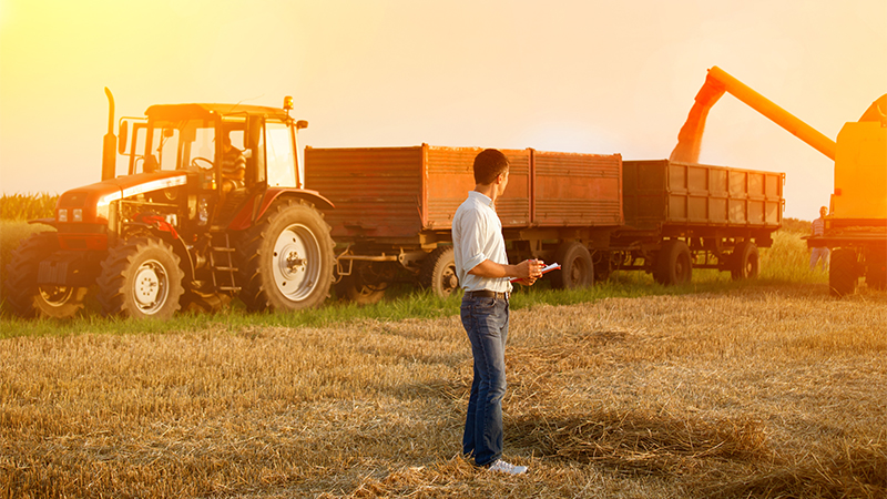 Man looking at tractor behind him 