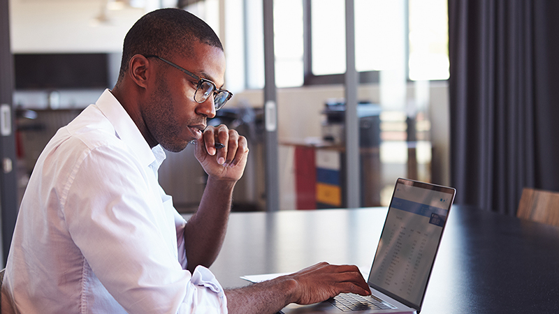 A businessman using a laptop at a table
