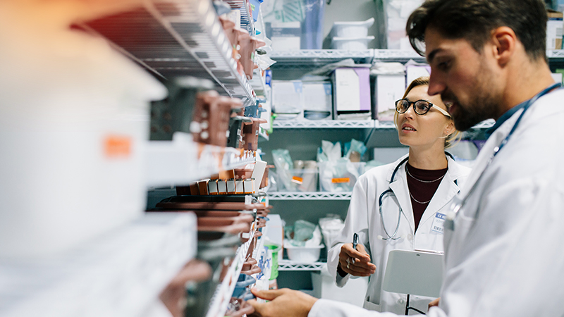Two doctors looking at a shelf of inventory 