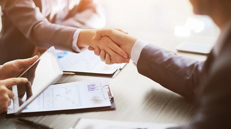 Business people shaking hands at table